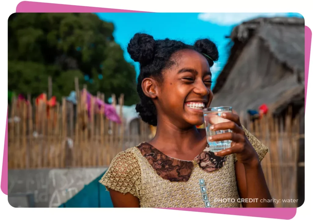 Young girl with a glass of water smiling