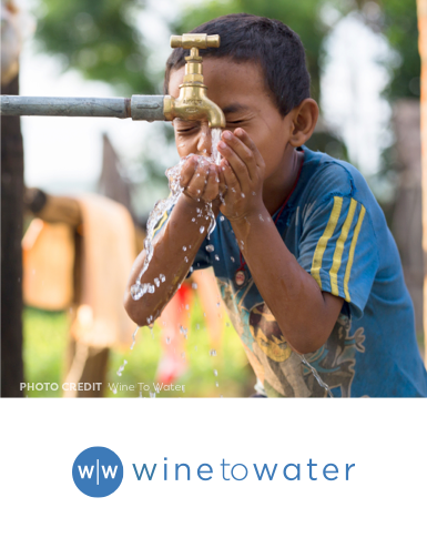 young boy drinking water from a water tap