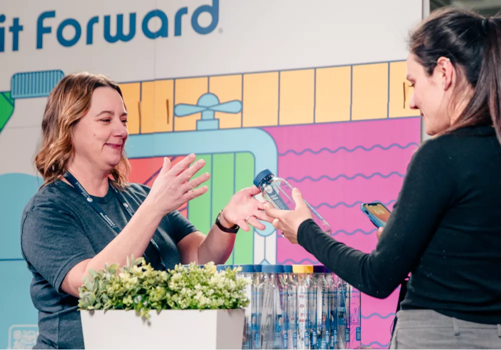one women showing another a cupanion bottle at a tradeshow
