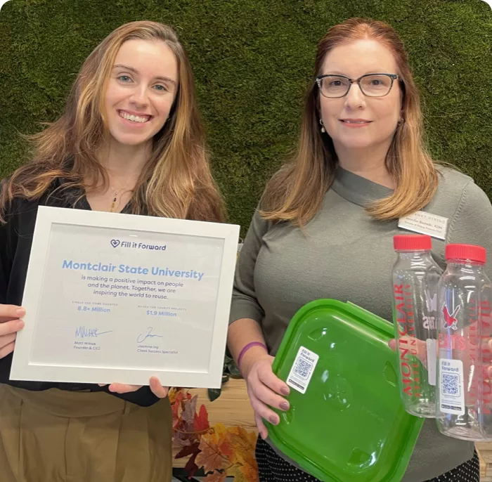 Two women holding fill it forward impact report, borrow container and cupanion bottles