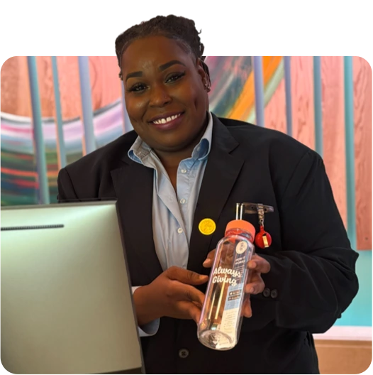 Front desk lobby worker smiling with cupanion bottle